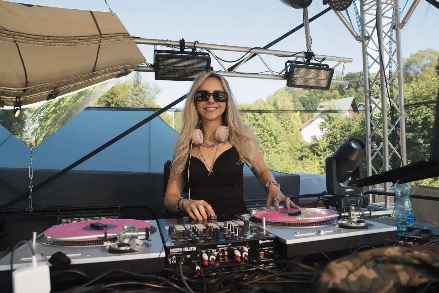 Festival TLAK 2026 — DJka za gramofony během denního setu