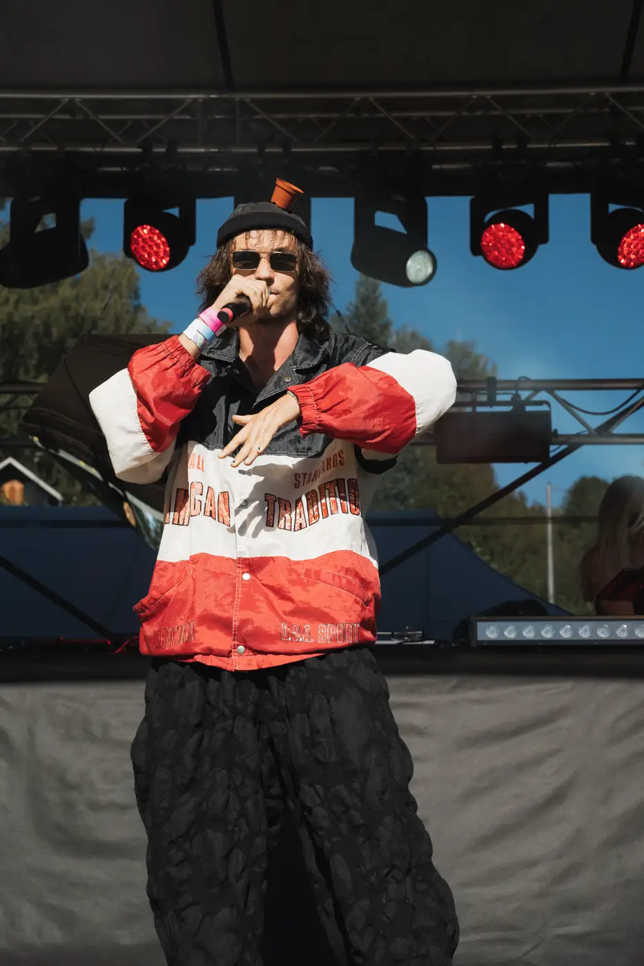 Festival TLAK 2026 — Rapper v červenobílé bundě s mikrofonem na Rap Stage