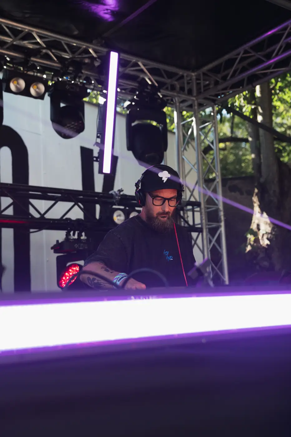 Festival TLAK 2026 — DJ za pultem v purpurovém světle