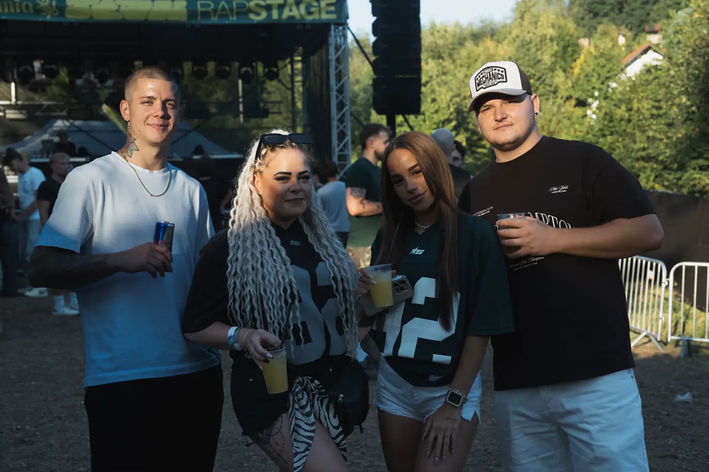 Festival TLAK 2026 — Parta návštěvníků s pitím před pódiem