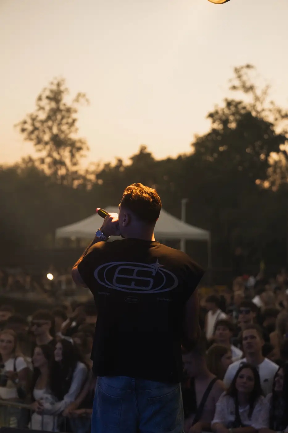 Festival TLAK 2026 — Rapper na pódiu proti zapadajícímu slunci