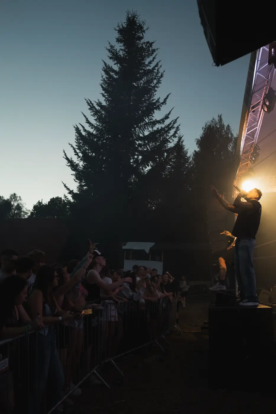 Festival TLAK 2026 — Silueta stromu nad pódiem za soumraku