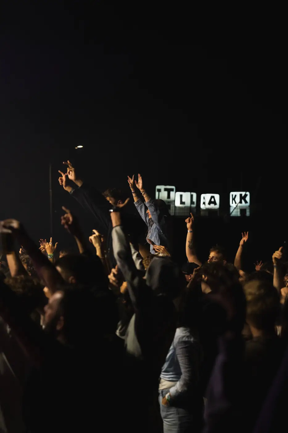 Festival TLAK 2026 — Dav se zdviženýma rukama a cedulí TLAK