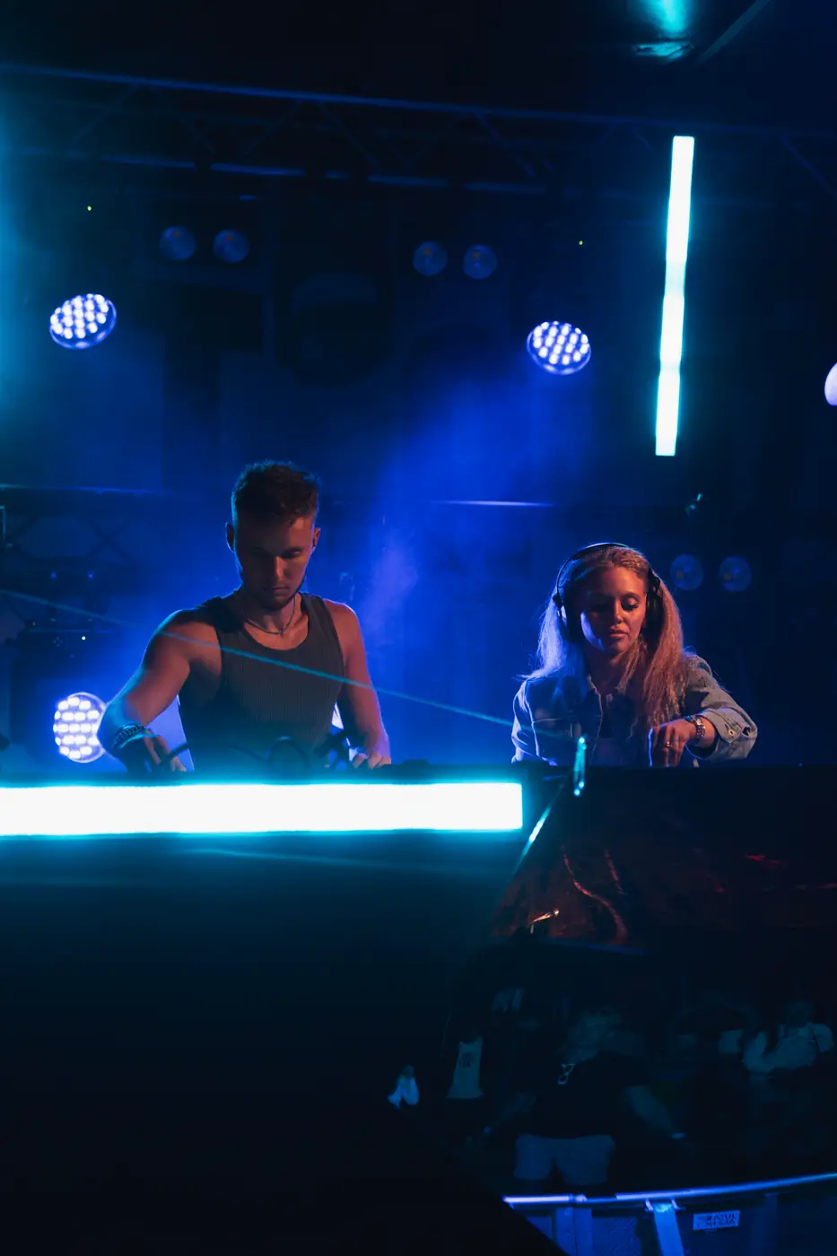 Festival TLAK 2026 — DJské duo za pultem v modrém světle
