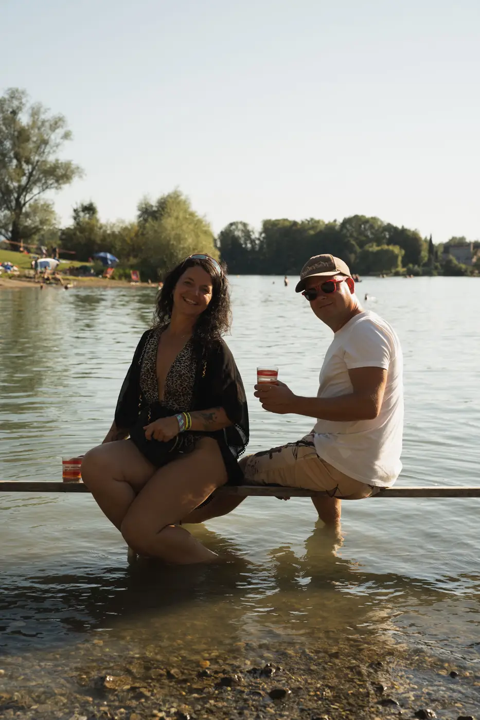 Festival TLAK 2026 — Návštěvníci s nápoji u vody