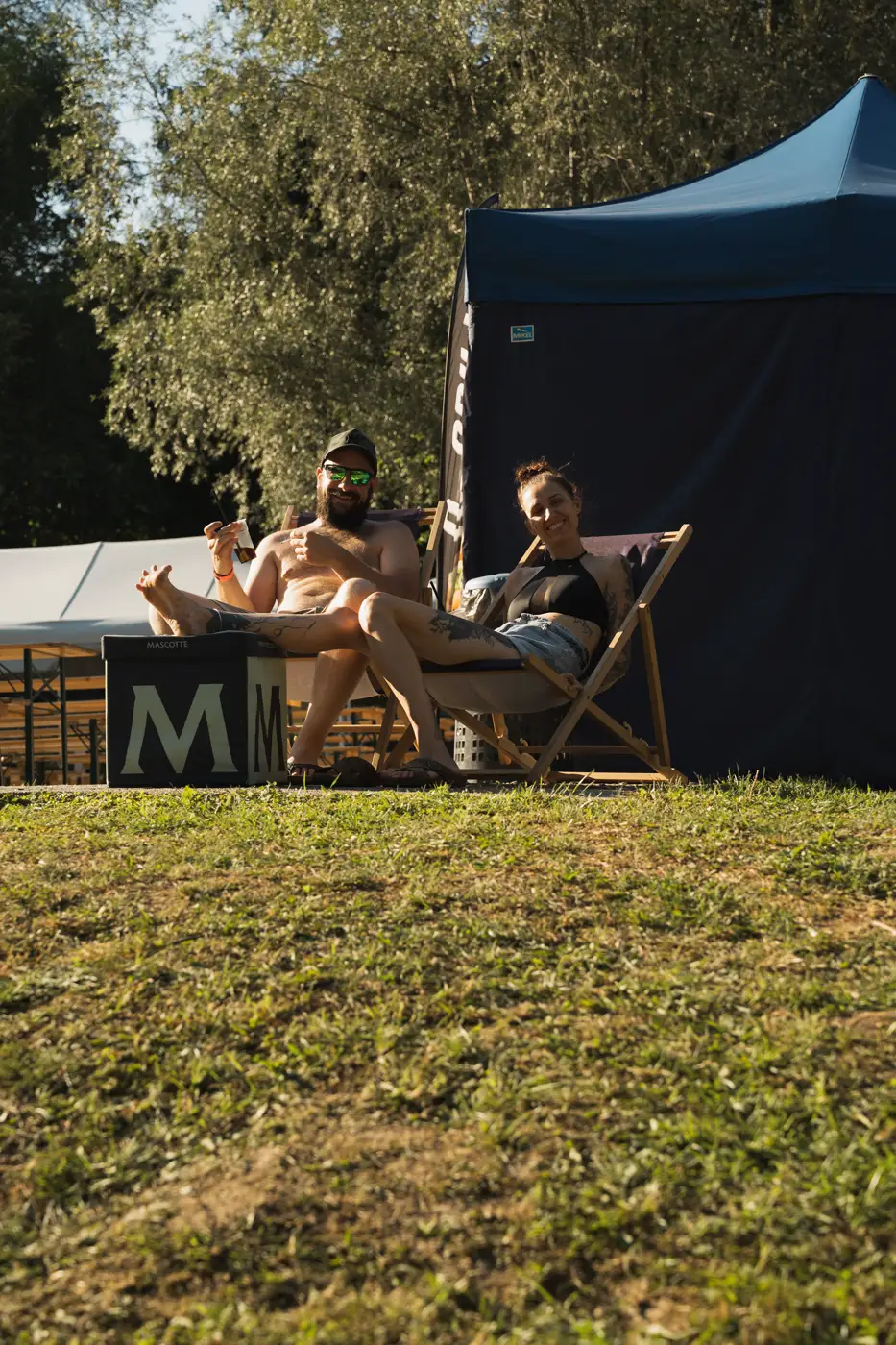Festival TLAK 2026 — Lehátka a stánek v odpoledním slunci