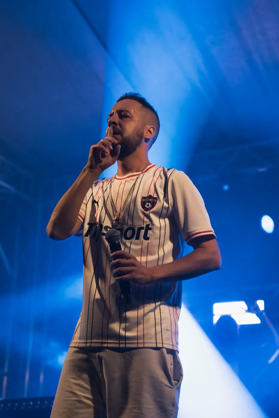 Festival TLAK 2026 — Rapper v modrém světle na pódiu