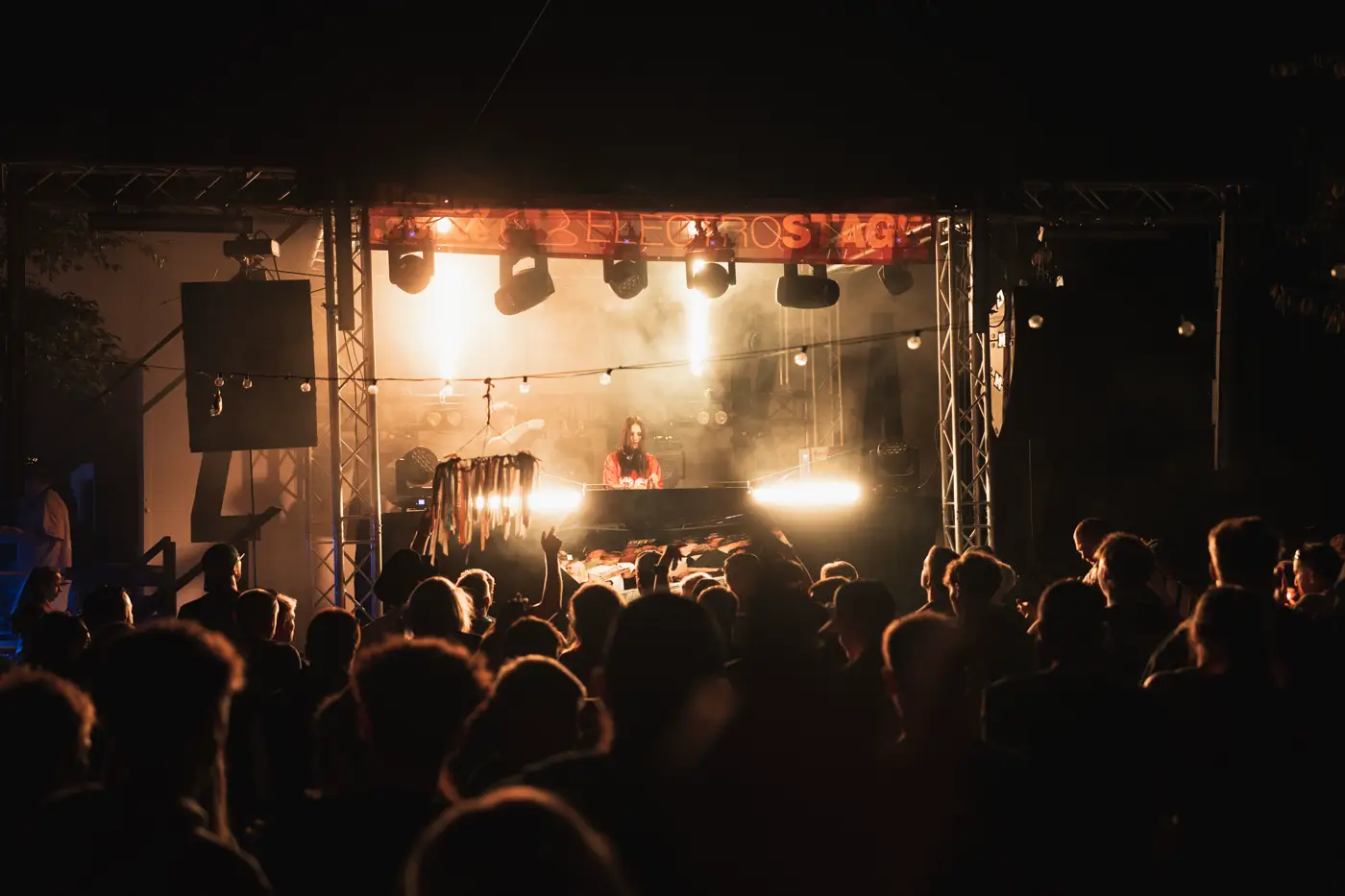 Festival TLAK 2026 — Pódium v teplých světlech a dav v noci